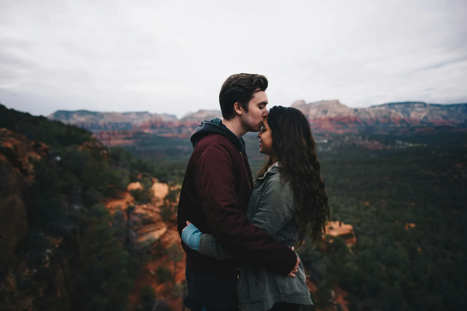 Couple embracing on a viewpoint above red rock canyons in Arizona.