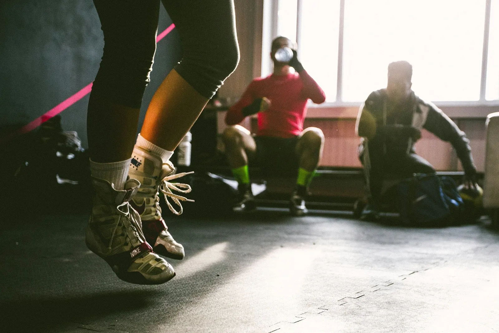 A morning HIIT session at a fitness camp, jump rope drills and circuit work in low light.